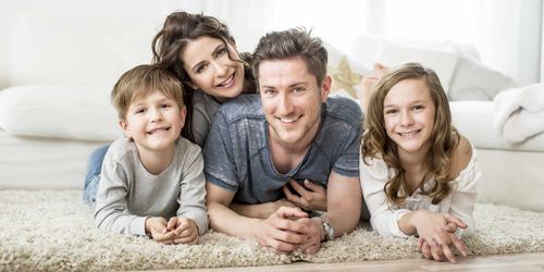 Hirdes & Partner Rechtsanwälte in Braunschweig, fröhliche Familie liegt auf einem weichen Teppich